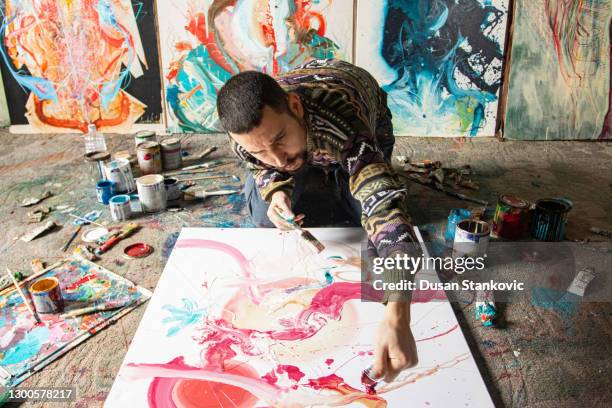 young artist doing his artwork - man painting on canvas stock pictures, royalty-free photos & images