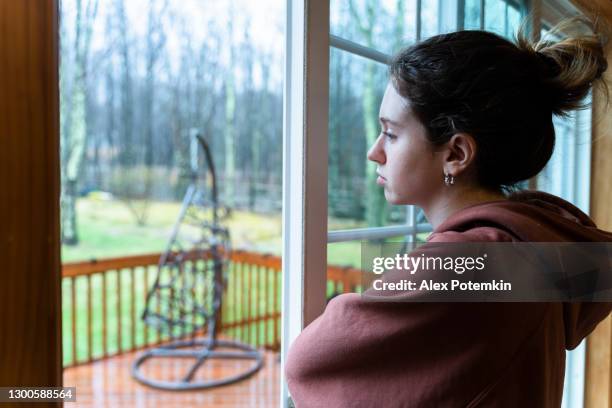 sad girl looking outside through a window. - girl from behind stock pictures, royalty-free photos & images