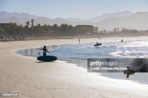 Surfers with their boards on the beach of "Los Cerritos" prepare to enter the sea as part of the sport activities practiced in the town of Todos...