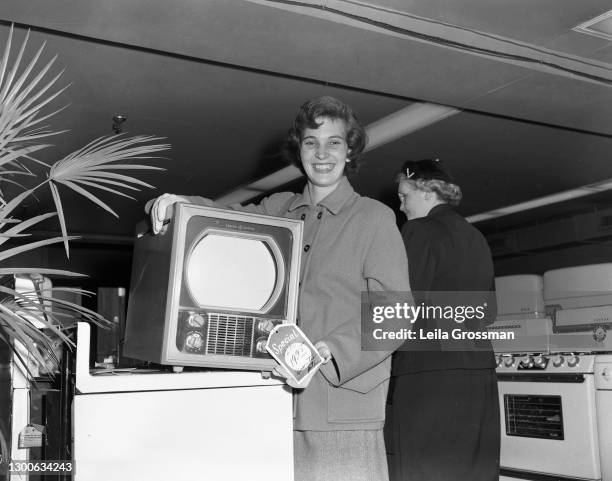 Woman poses with a General Electric television for WKDA radio 1954 in Nashville, Tennessee.