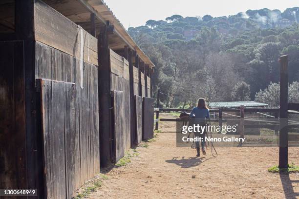 pretty girl walking through the stables - cavalls stock pictures, royalty-free photos & images