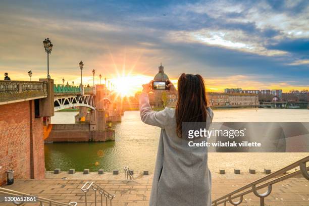 a girl standing to watch the sun in garonne river and dome de la grave in toulouse, france. - toulouse stock pictures, royalty-free photos & images