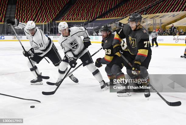 Anze Kopitar and Dustin Brown of the Los Angeles Kings and Alec Martinez and William Karlsson of the Vegas Golden Knights go after the puck after a...