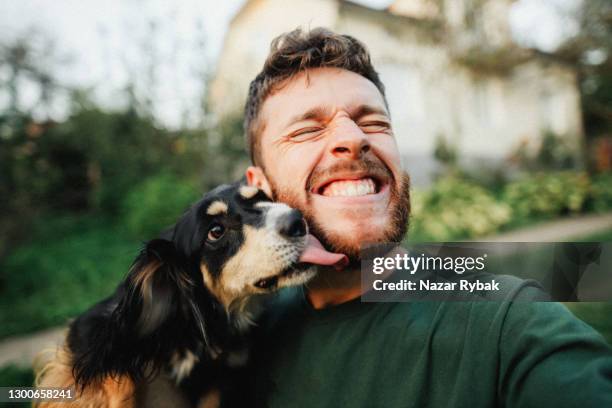ung man leker med en hund och gör selfie - happy man bildbanksfoton och bilder