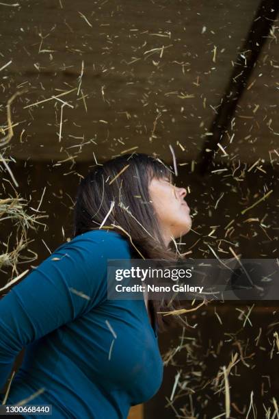 cute woman surrounded by straw, which is floating in the air - cavalls stock pictures, royalty-free photos & images
