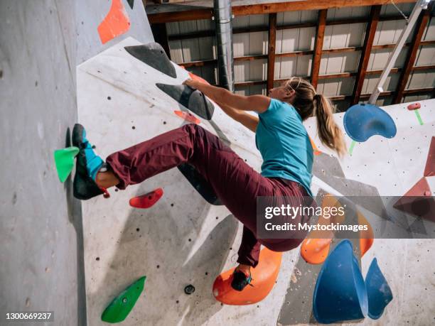 woman indoor climbing in boulder gym - bouldern indoor stock pictures, royalty-free photos & images