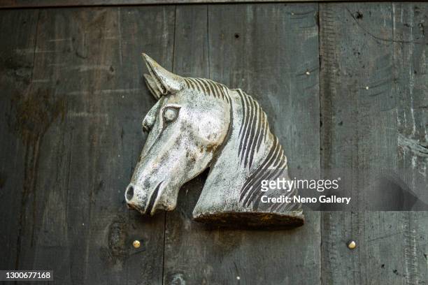 steel horse hanging from a gate of a stable - cavalls stock pictures, royalty-free photos & images