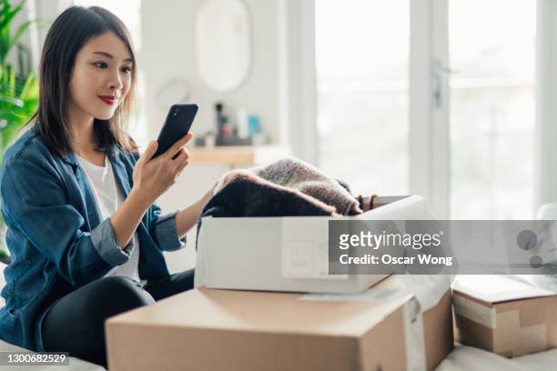 young woman doing online shopping with smartphone - shopaholic woman stock pictures, royalty-free photos & images