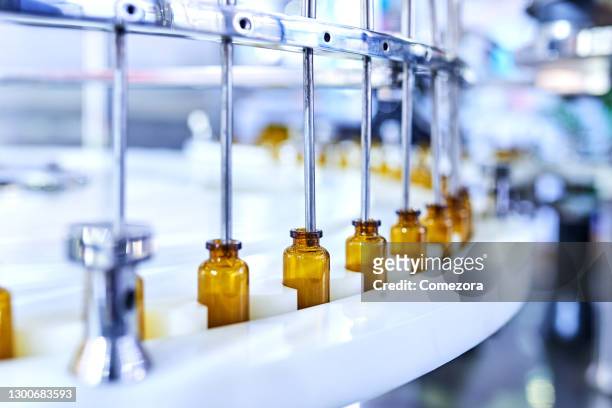 brown medicine glass bottles on production line - バイオテクノロジー ストックフォトと画像