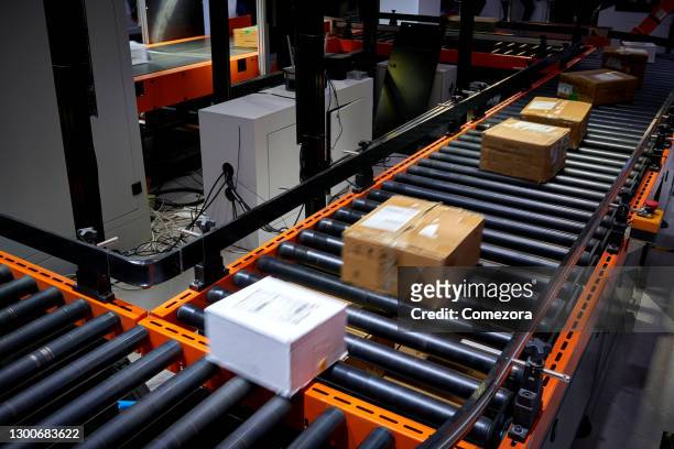 cardboard box at logistics factory's conveyor belt - conveyor belt bildbanksfoton och bilder