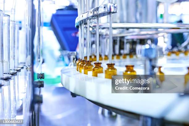 brown medicine glass bottles on production line - farmaceutische-fabriek stockfoto's en -beelden