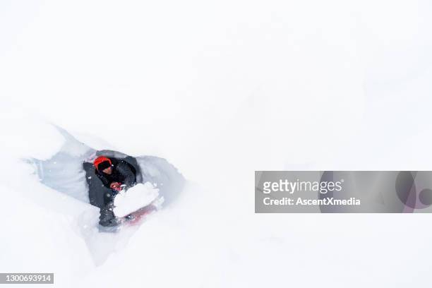 young man digs through fresh powder snow in the morning - powder snow imagens e fotografias de stock