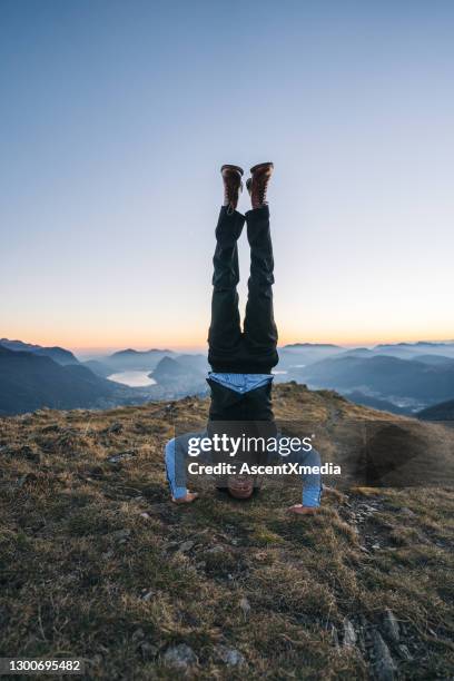 smartly dressed man does handstand in mountains, dawn - upside down stock pictures, royalty-free photos & images