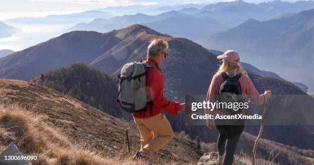 casal maduro caminha ao longo da ensolarada montanha - ridge - fotografias e filmes do acervo