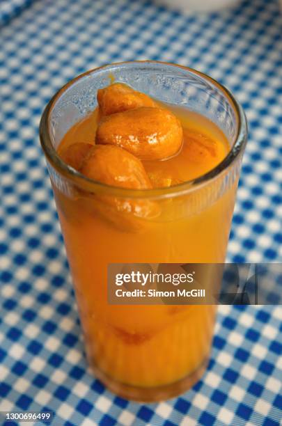 jobito / jocote / jobo (spondias purpurea) flavored water, with whole fruit, in a drinking glass - spondias mombin stock pictures, royalty-free photos & images