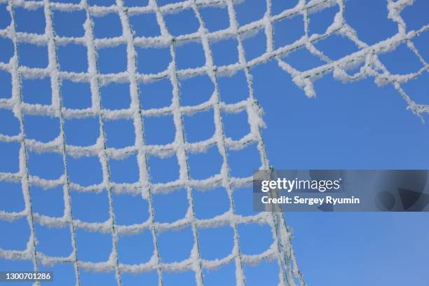 torn knitted mesh covered with frost - netzgewebe stock-fotos und bilder