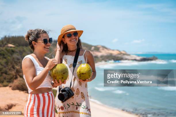 vrouwen die kokoswater drinken bij praia do amor in rio grande do norte - natal brasil stockfoto's en -beelden