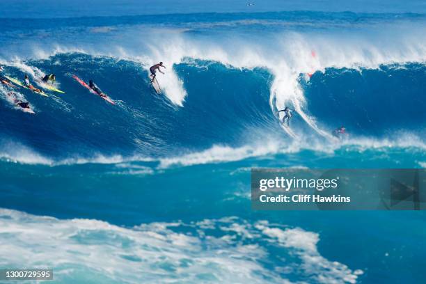 Surfers catch a wave at Waimea Bay on January 15, 2021 in Haleiwa, Hawaii.
