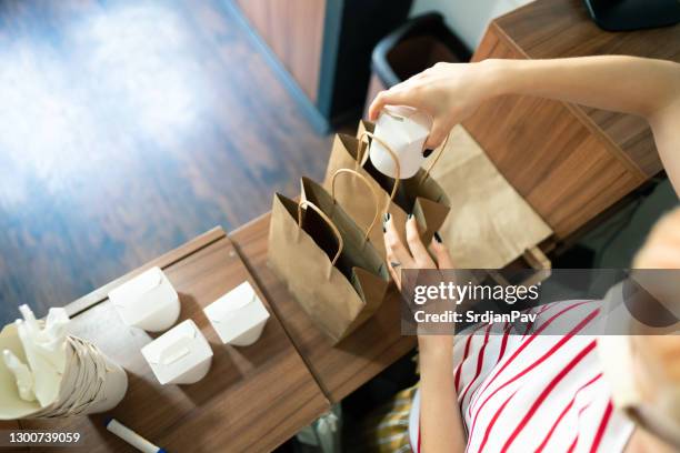 close up of woman packing food for delivery - white fast food bag stock pictures, royalty-free photos & images