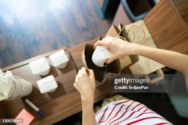 top view of fast food worker packing food for delivery - takeaway box stock pictures, royalty-free photos & images