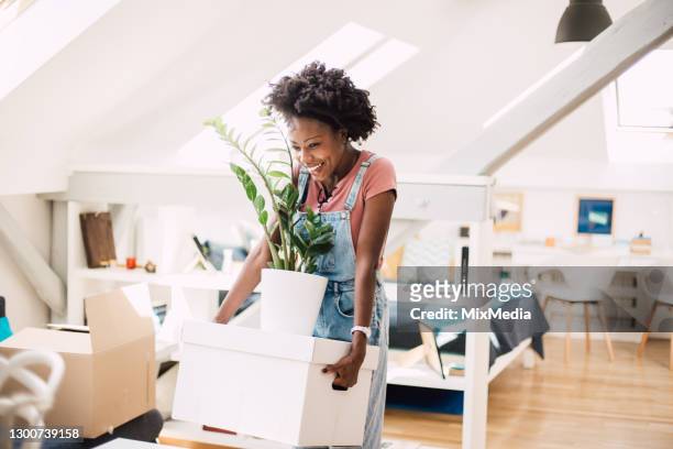 happy african-american woman moving into a new home - moving house stock pictures, royalty-free photos & images