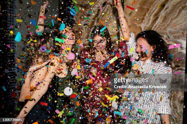 group of friends having fun with confetti at home. - fiesta fotografías e imágenes de stock