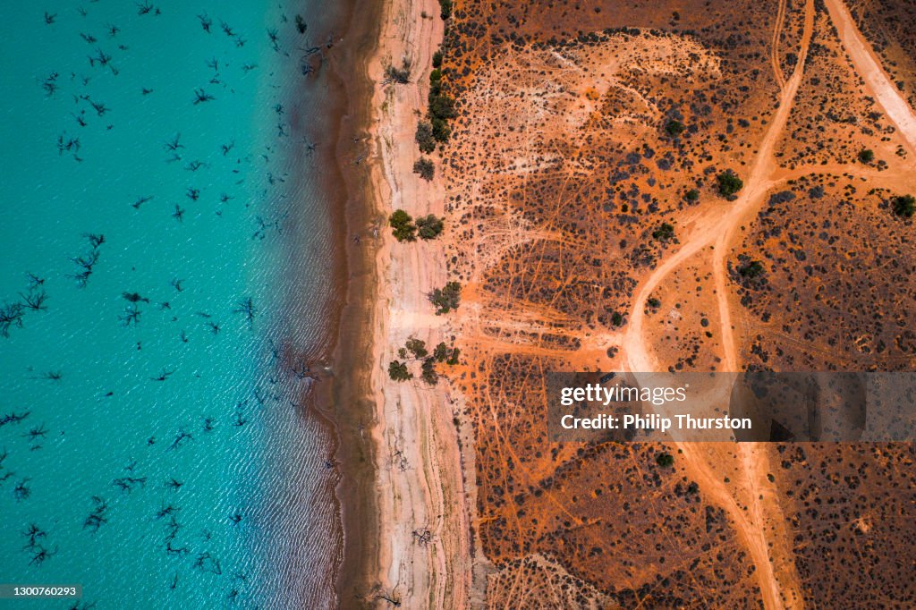 Aerial view of arid desert dry landscape and blue lake in outback Australia