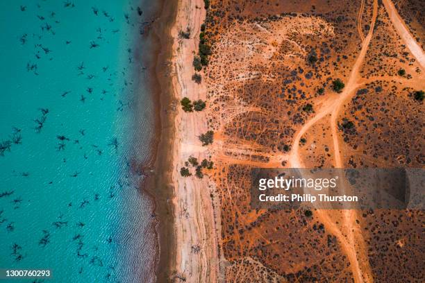 aerial view of arid desert dry landscape and blue lake in outback australia - australia stock pictures, royalty-free photos & images