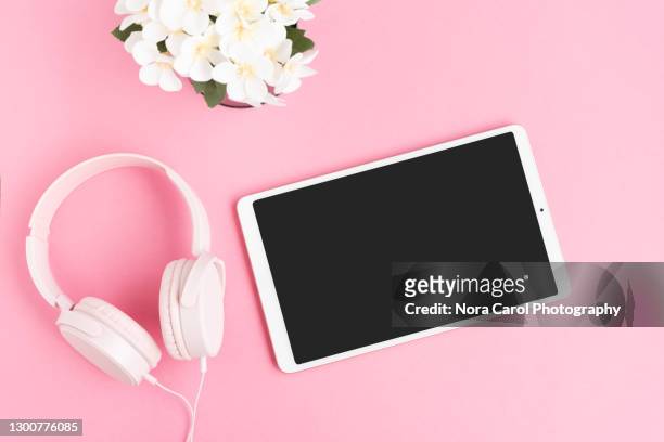 pink headphone and digital tablet on pink background - movie still stock-fotos und bilder