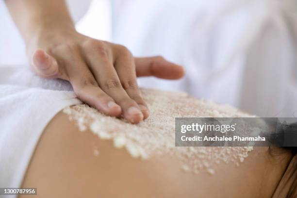 spa, beauty and relaxing concept: the lady relaxing on the massage table and get the salt scrub in the spa - exfoliant stock pictures, royalty-free photos & images