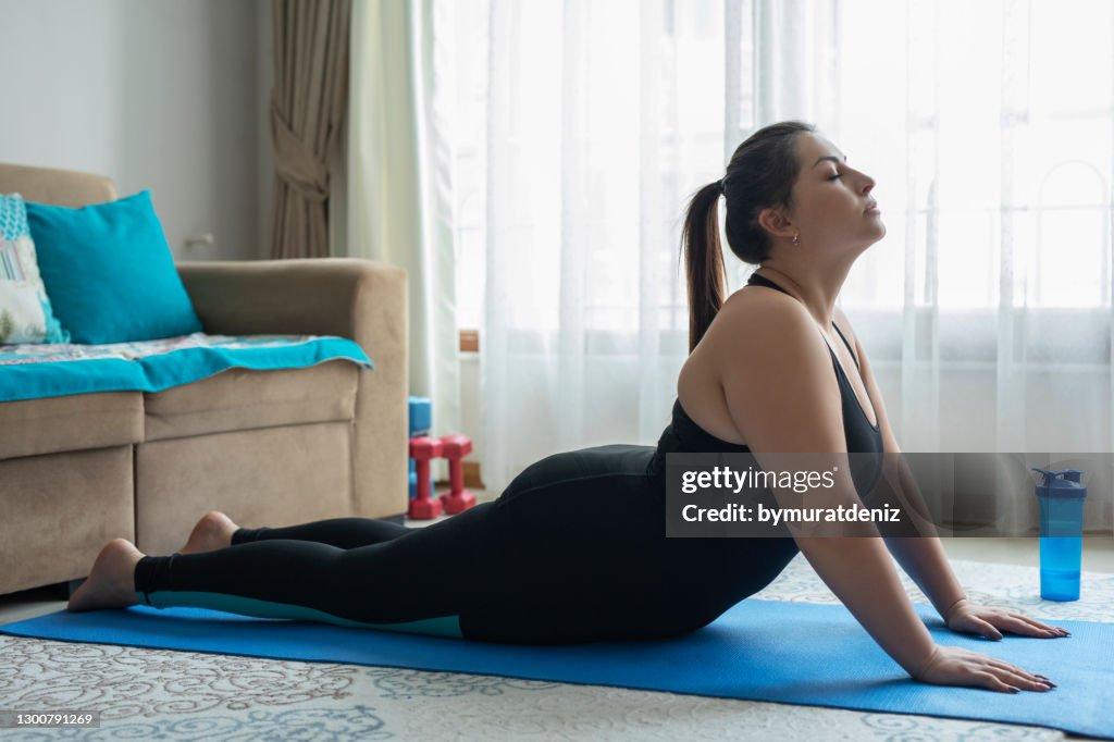 Plus size woman practicing cobra pose