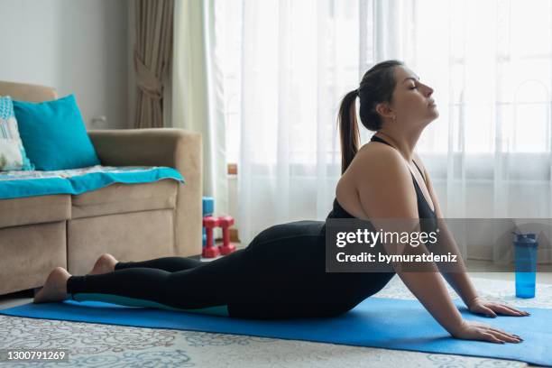 plus size woman practicing cobra pose - coronavirus curve stock pictures, royalty-free photos & images