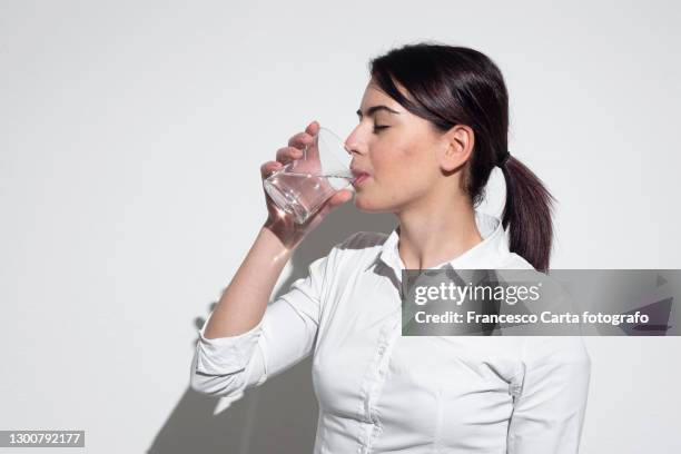 woman drinking glass of water - drinking water glass woman stock-fotos und bilder