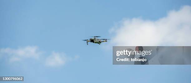 fliegende drohne und blauer himmel - unbemanntes luftfahrzeug stock-fotos und bilder