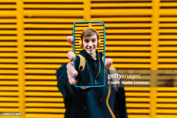man showing a selfie taken with his cell phone - self portrait photography stockfoto's en -beelden