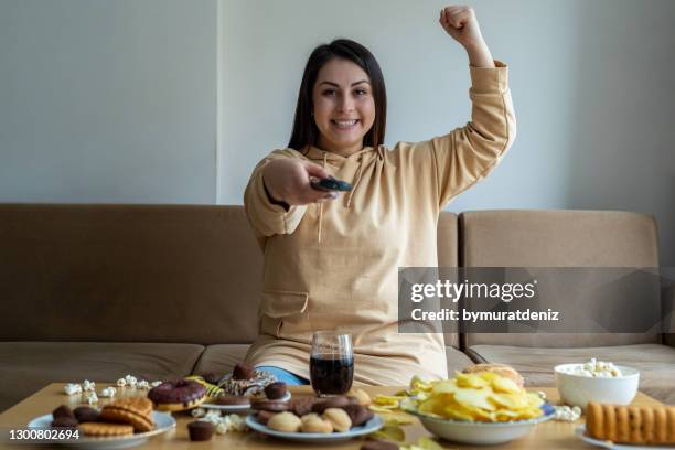 woman watching sport game on tv - potato chips and soda stock pictures, royalty-free photos & images