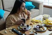 Overweight young woman eating junk food