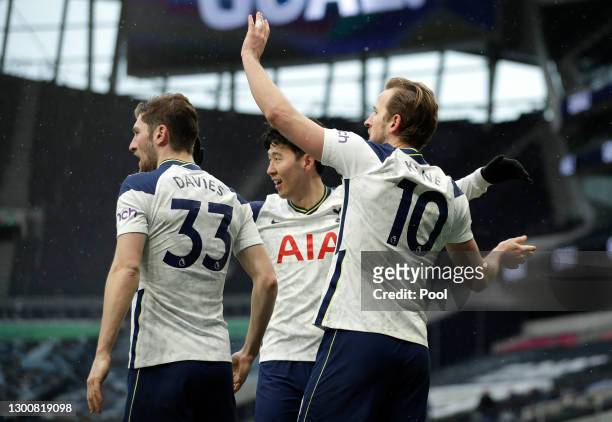 Harry Kane of Tottenham Hotspur celebrates with team mates Ben Davies and Son Heung-Min after scoring their side's first goal during the Premier...