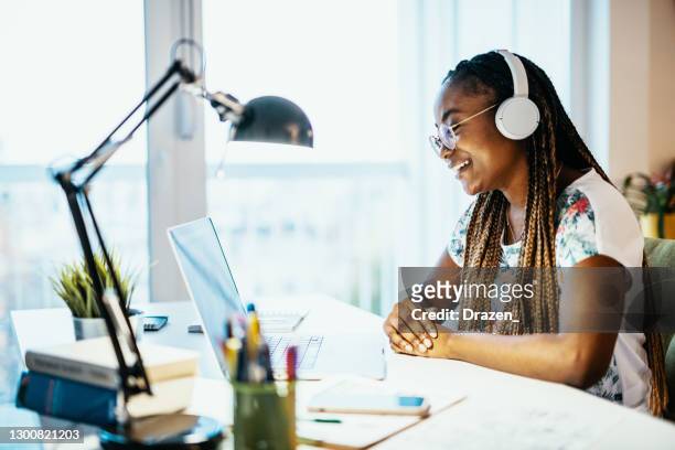 smiling african american female student studying from home and using video conference call - leanincollection stock pictures, royalty-free photos & images