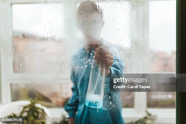 young male cleaning windows at home - putzfrau stock-fotos und bilder