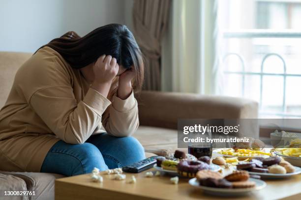 mujer infeliz estresada - over eating fotografías e imágenes de stock