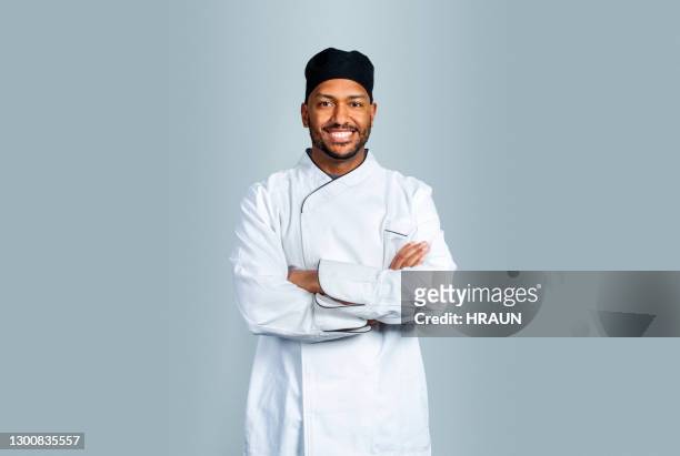 cocinero macho sonriente sobre fondo gris - uniforme de chef fotografías e imágenes de stock