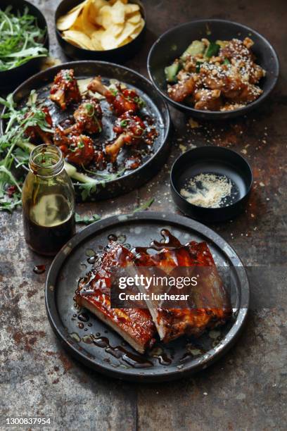 barbecue costolette di maiale glassate piccanti e ali di pollo lecca-lecca - texas v kansas foto e immagini stock