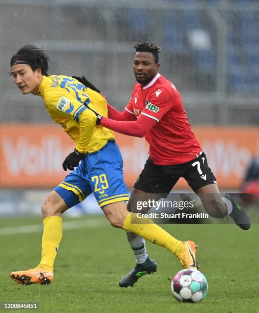 Patrick Twumasi of Hannover is challenged by Dong-won Ji of Braunschweig during the Second Bundesliga match between Eintracht Braunschweig and...