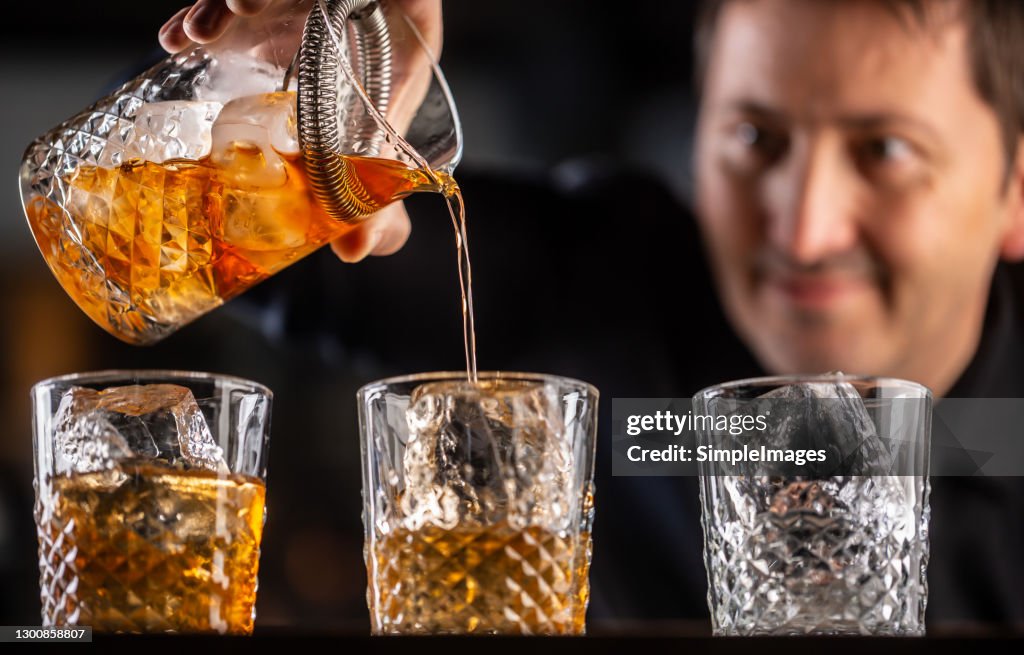 Whisky Bourbon On Ice Being Prepared By A Professional Bartender Pouting  The Drink Into Ornamental Glasses High-Res Stock Photo - Getty Images