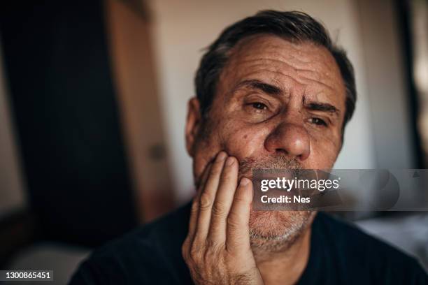 a mature man with a toothache - toothache stock pictures, royalty-free photos & images