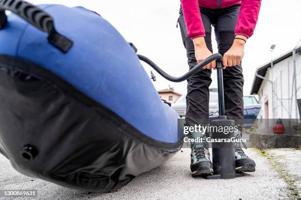 adult woman inflating canoe outdoors on street - air pump stock pictures, royalty-free photos & images