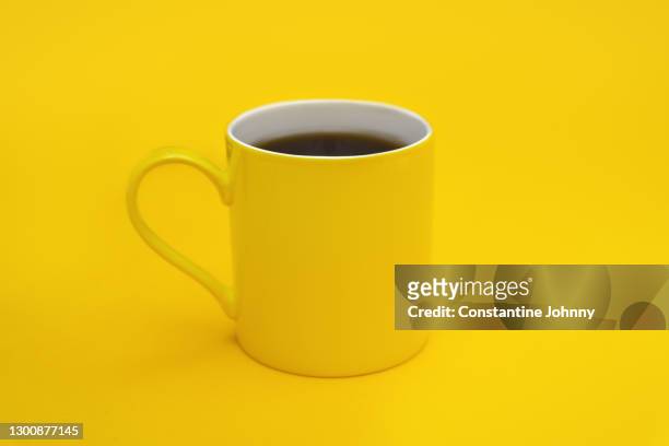 yellow coffee mug against yellow background - coffee cup stock-fotos und bilder