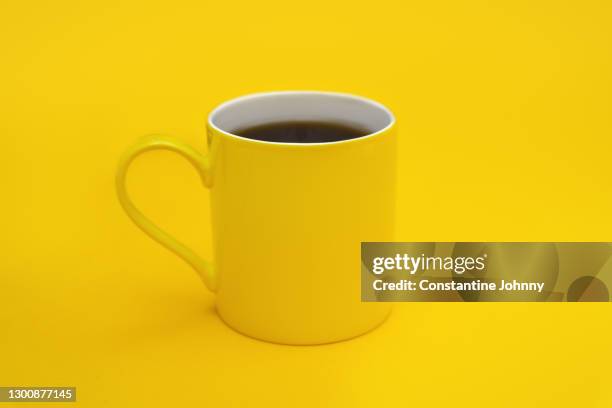 yellow coffee mug against yellow background - black mug stock pictures, royalty-free photos & images