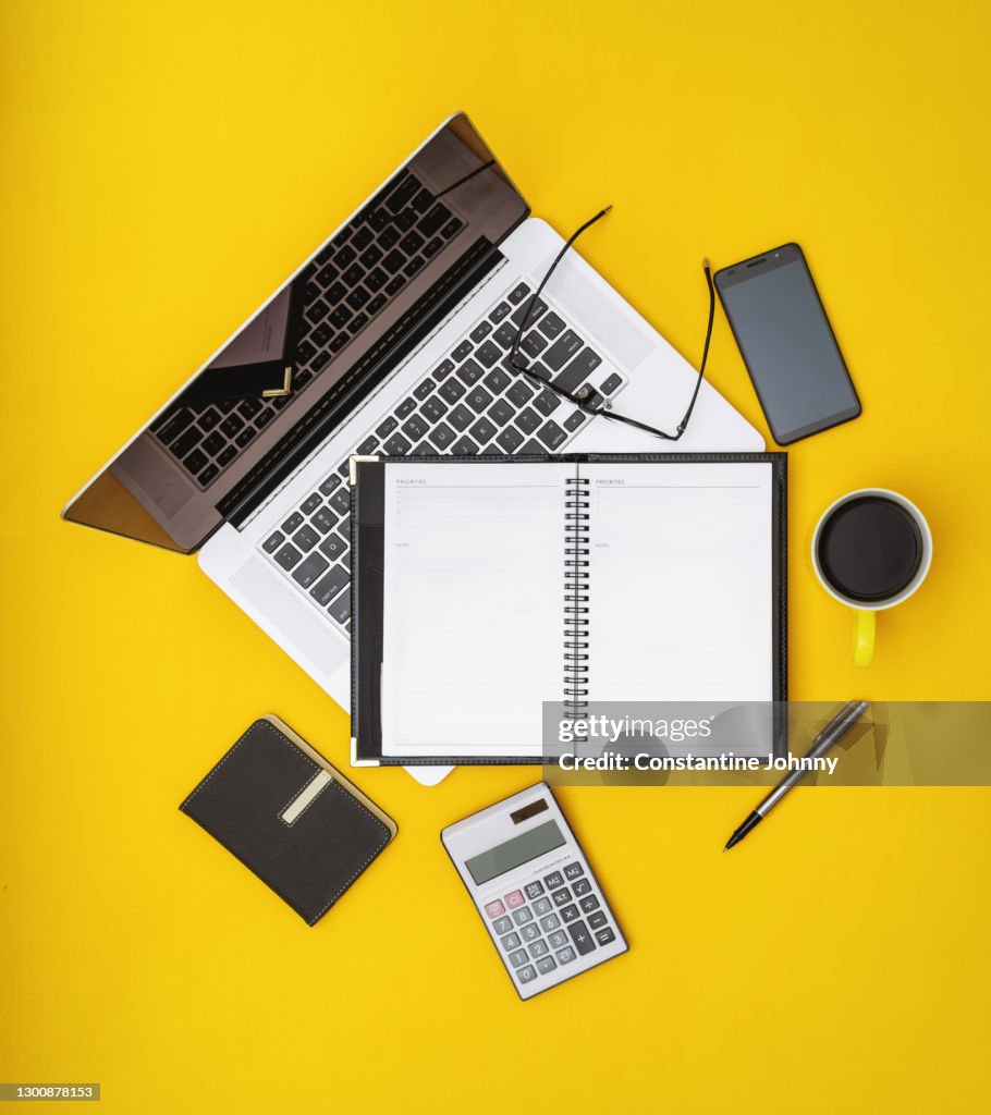 Personal Organizer and Laptop on Yellow Desk